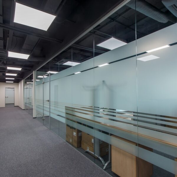 A large open corridor showcasing a glass office partition.
