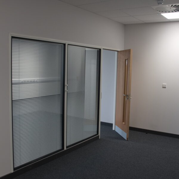 Office partitioning installation with a glass window partition and a door